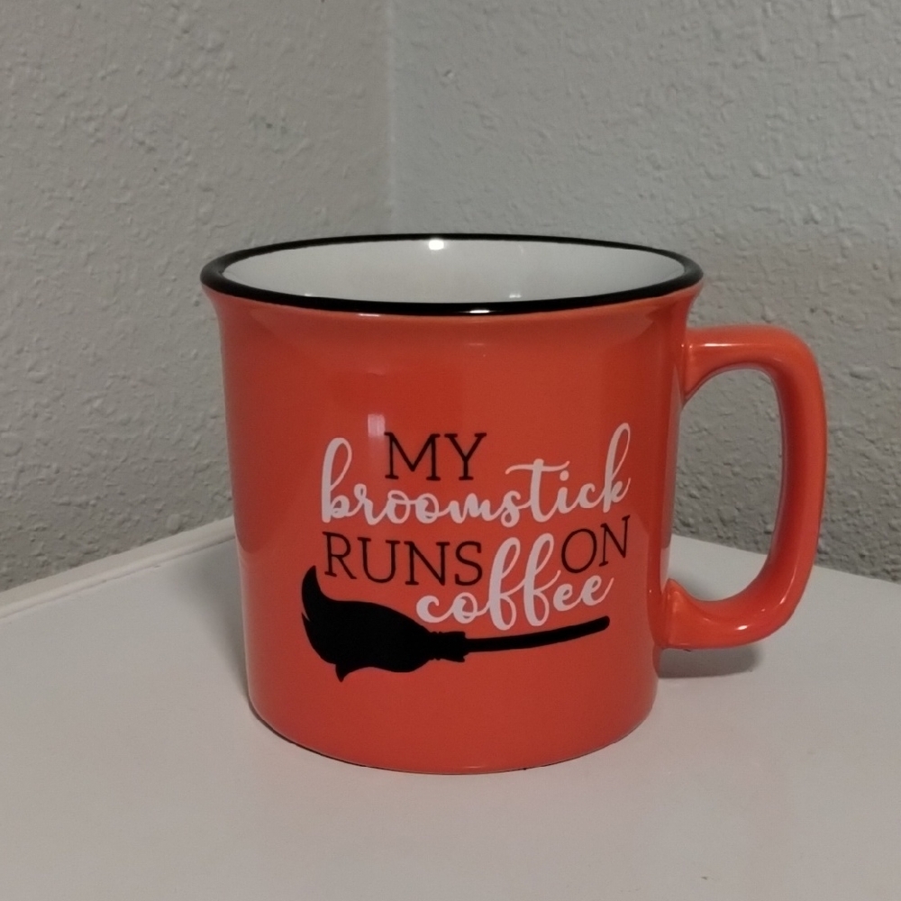 Playful Orange Coffee Mug with Broomstick Design